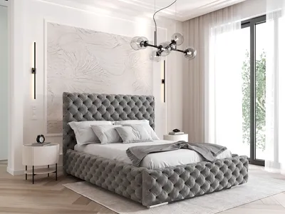 A bedroom with a large tufted bed, nightstand, and window.