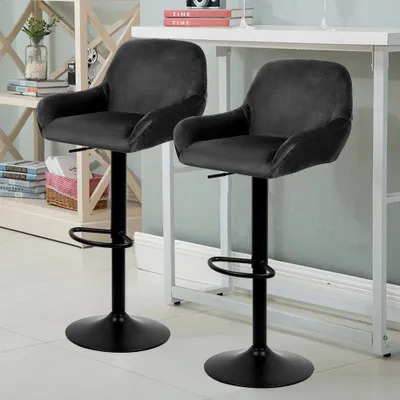 Two black bar stools are shown in a room with a white table and shelves in the background.