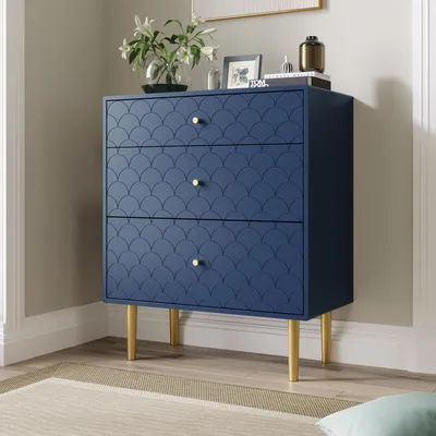 A navy blue dresser with a scalloped pattern and gold legs is shown in a room.