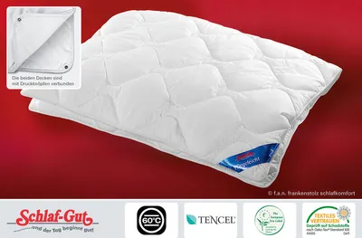 A white quilted duvet is displayed diagonally on a red background. Several logos and text snippets are visible at the bottom and in the top-left corner.