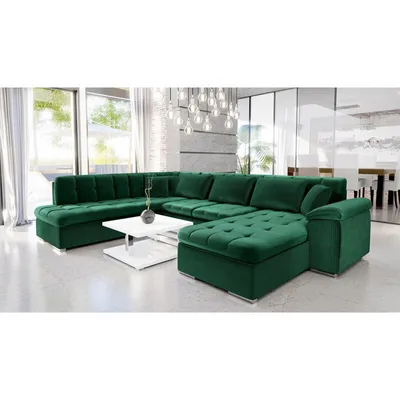 A spacious green sectional sofa is displayed in a modern living room setting with large windows and a contemporary chandelier.