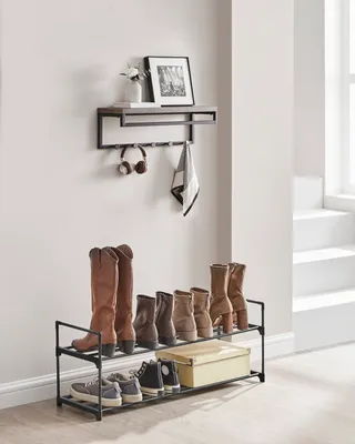 A shelf and shoe rack setup against a wall with a window and stairs in the background.