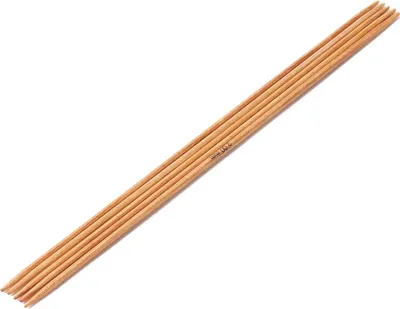 A set of wooden knitting needles laid out diagonally on a white background.