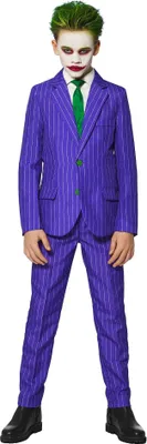 A young boy dressed as the Joker stands against a white background.