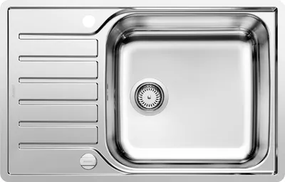 A top-down view of a stainless steel kitchen sink with a drainboard.