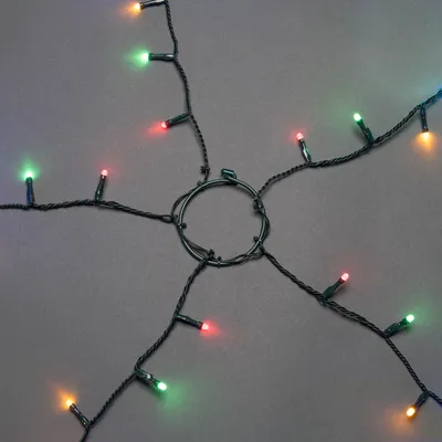 A close-up, overhead view of a string of LED lights arranged in a starburst pattern around a central ring.