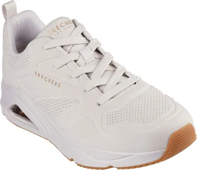 A white Skechers sneaker with a tan sole is shown against a white background.