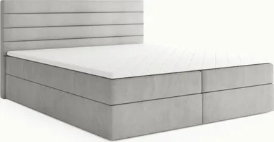 A light gray upholstered boxspring bed with a white mattress and topper, shown from a three-quarter angle against a white background.