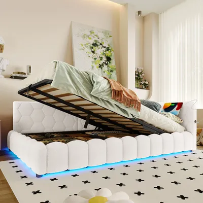 A white upholstered bed with its storage compartment open, revealing items stored inside. The bed has blue LED lighting around its base.