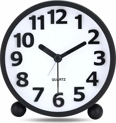 A close-up, front-facing view of a black and white analog alarm clock with large 3D numbers.