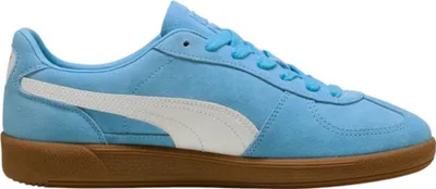 A side view of a blue Puma sneaker with a white stripe and a brown sole.