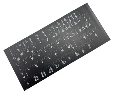 A sheet of black keyboard stickers with white lettering, laid out diagonally on a white background.