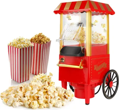A red retro-style popcorn machine with popcorn in containers and scattered on a white background.