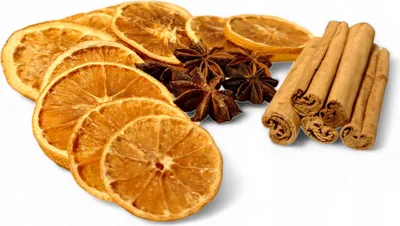 A collection of dried orange slices, star anise, and cinnamon sticks arranged on a white background.