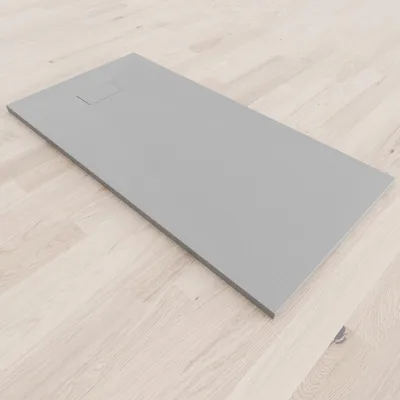 A gray shower tray is placed on a light wooden floor.