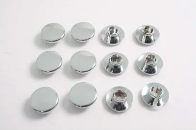 A top-down view of twelve chrome screw caps arranged in three rows of four on a white background.