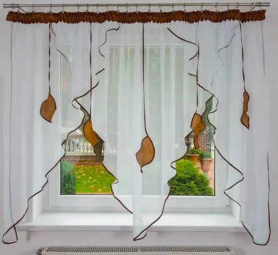 A sheer white curtain with brown trim and leaf-like embellishments hangs in front of a window, revealing a garden scene outside.