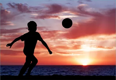Produktbild von Wallario Fototapete Vliestapete, seidenmatte Oberfläche, einfache Verarbeitung, Größe 200 x 140 cm, Motiv Fußball - Kleiner Junge spielt im Abendrot