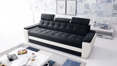 A modern living room with a black and white sofa, a coffee table, and artwork on the wall.