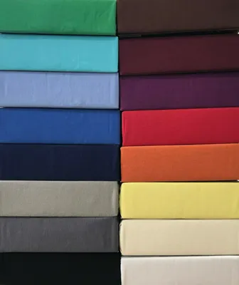 A stack of folded fabric sheets in various colors.