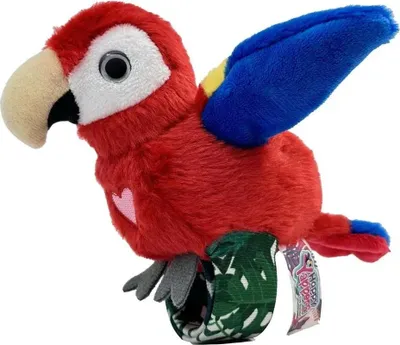 A plush toy parrot is shown from a side-diagonal angle, with its wings slightly raised. It is attached to a wristband with a tropical leaf pattern.