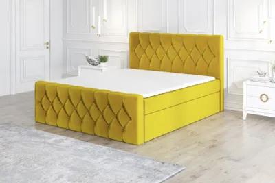 A yellow upholstered bed with a tufted headboard and footboard sits on a light gray rug in a brightly lit room.