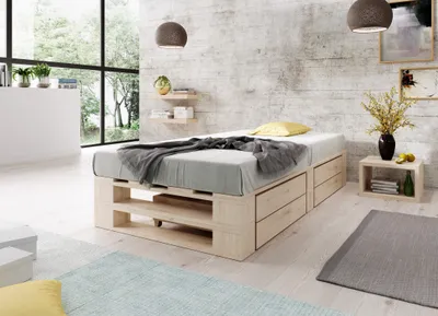 A bedroom with a wooden bed frame, bedding, and decorative items.