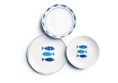 Three white plates with blue fish designs are arranged on a white background.
