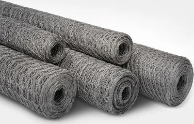 Several rolls of galvanized wire mesh are arranged diagonally on a white background.