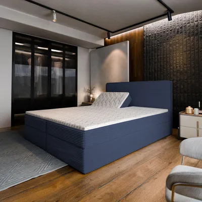 A bedroom scene with a blue boxspring bed as the main focus.