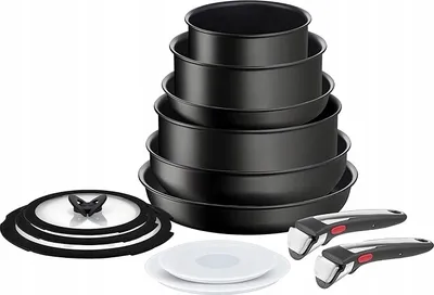 A set of nested black pots and pans with detachable handles and a glass lid.