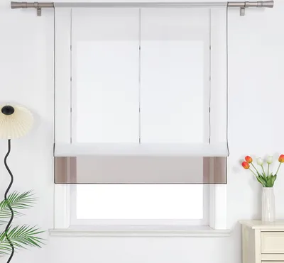 A window with a modern Roman blind and decorative elements.