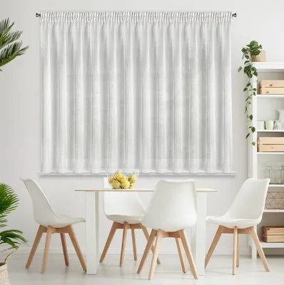 A dining set with a white table and chairs in front of a white curtain.