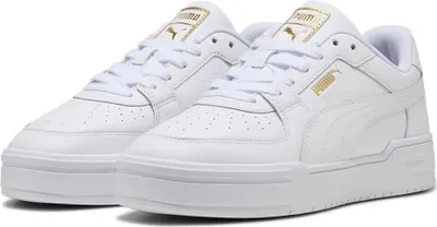 A pair of white Puma sneakers with gold accents.