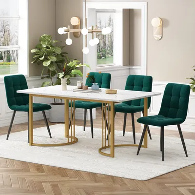 A dining room scene featuring a marble-top dining table with gold geometric legs and four green velvet dining chairs.