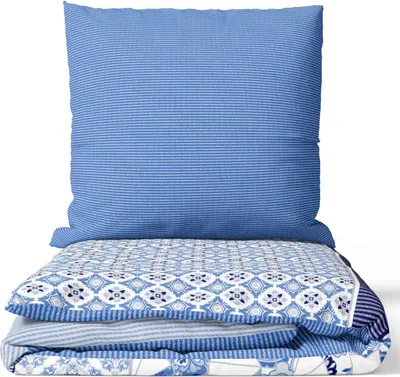 A neatly folded set of bedding, including a pillow and duvet, with a blue and white striped and patterned design.