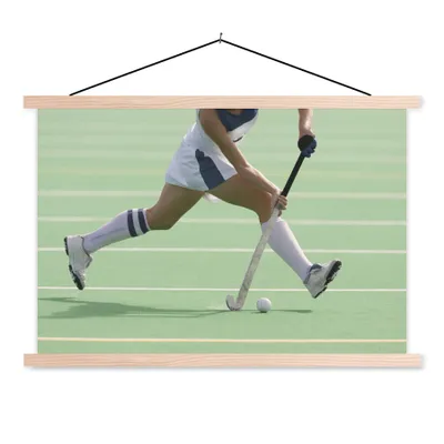 Produktbild von MuchoWow® Textilposter Hockeystar dribbelt mit dem Ball 120x80 cm mit holzfarbenen Rahmen - Aufhängeset