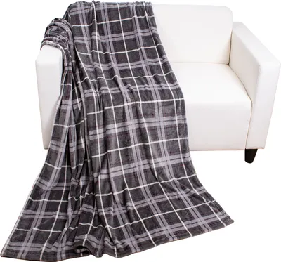 A plaid blanket draped over a white sofa.