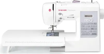 A white Singer sewing machine with an attached extension table.
