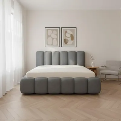 A bedroom with a bed, two framed pictures on the wall, and a chair.