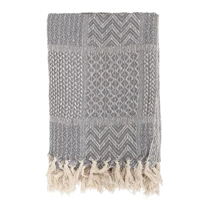 A folded blanket with a patterned texture and tassels.