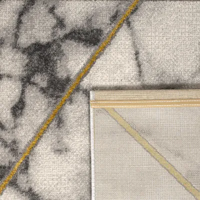 A close-up view of a rug, showing the texture and pattern. The rug has a marble-like design with gray and white tones, accented by a thin yellow line.
