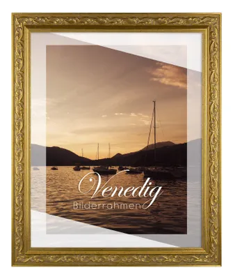 A gold picture frame with a scenic image of boats on water at sunset inside.