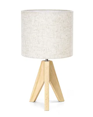 A table lamp with a beige fabric shade and a wooden tripod base, shown against a white background.