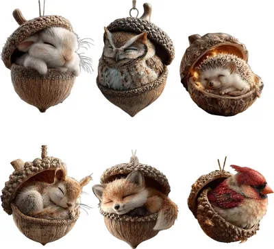 A collage of six different animal ornaments, each nestled inside a brown acorn shell. The animals include a rabbit, owl, hedgehog, squirrel, fox, and cardinal.