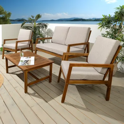 Outdoor patio furniture set on a wooden deck with a body of water and distant hills in the background.