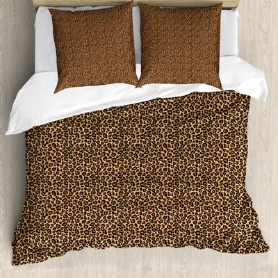 A top-down view of a bed with a leopard print duvet cover and two pillows.