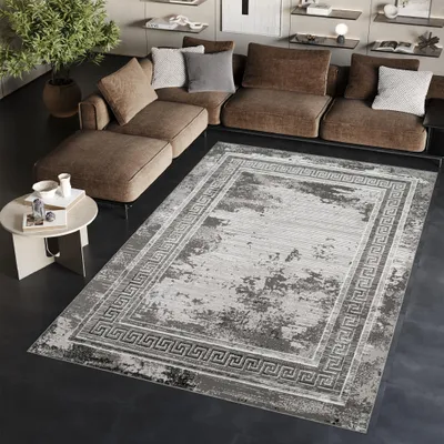 A modern living room with a sectional sofa, a rug, and a side table.