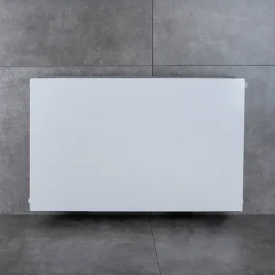 A white radiator panel is shown mounted on a gray tiled wall.