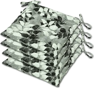 A stack of four chair cushions with a leaf pattern.
